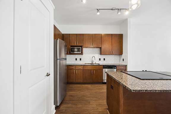 A kitchen with wooden cabinets and a black counter top.