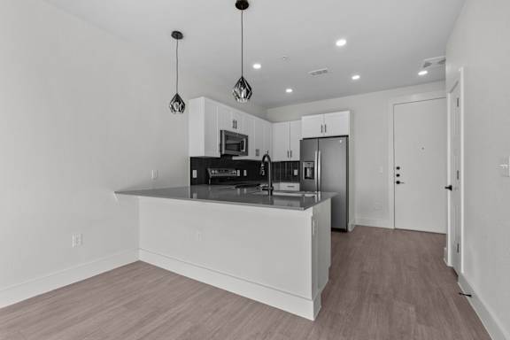A modern kitchen with a white island and stainless steel appliances.