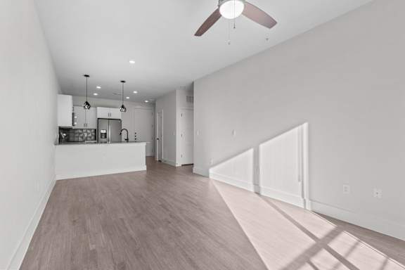 A spacious room with a ceiling fan and lighting fixtures.