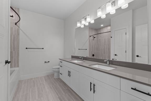 A bathroom with a vanity, toilet, and a shower.