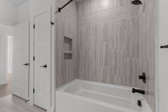 A white bathroom with a tub and a walk in shower.