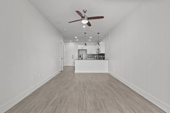 A room with a ceiling fan and lighting fixtures.