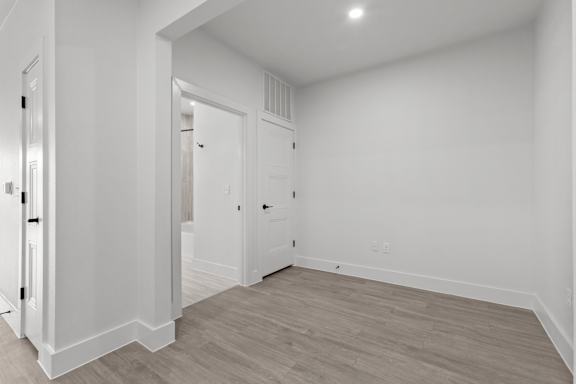 A white room with a wooden floor and two doors.