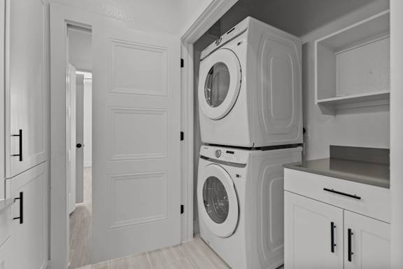 A laundry room with a washer and dryer stacked on top of each other.