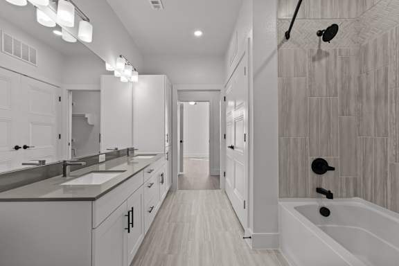 A modern bathroom with a walk-in shower and double sinks.
