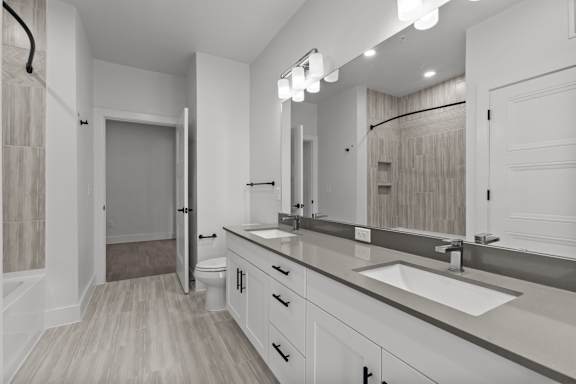 A bathroom with a sink, mirror, and toilet.
