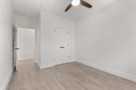 A room with a ceiling fan and two doors.