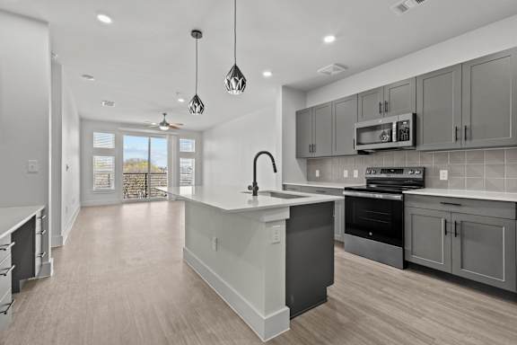 A modern kitchen with a large island and stainless steel appliances.