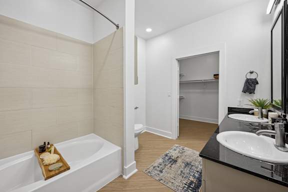 A bathroom with a white tub and sink.