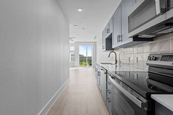 A modern kitchen with stainless steel appliances and a view of the city.