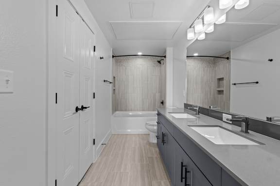 A white bathroom with a toilet, sink, and mirror.