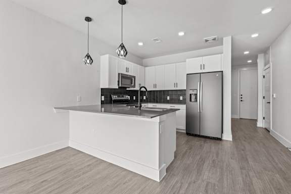 A modern kitchen with a white island and stainless steel appliances.