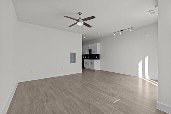 A room with a ceiling fan and wooden flooring.
