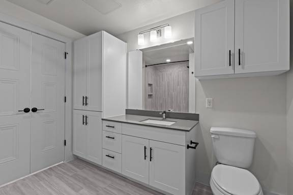 A white bathroom with a toilet, sink, and medicine cabinet.