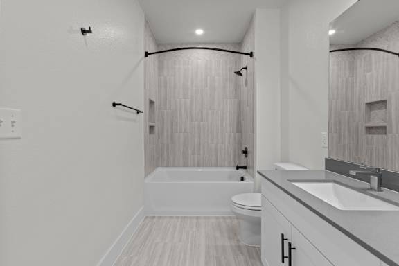 A white bathroom with a toilet, sink, and bathtub.