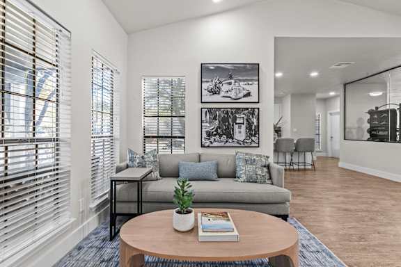 A living room with a couch, a coffee table, and a plant on it.