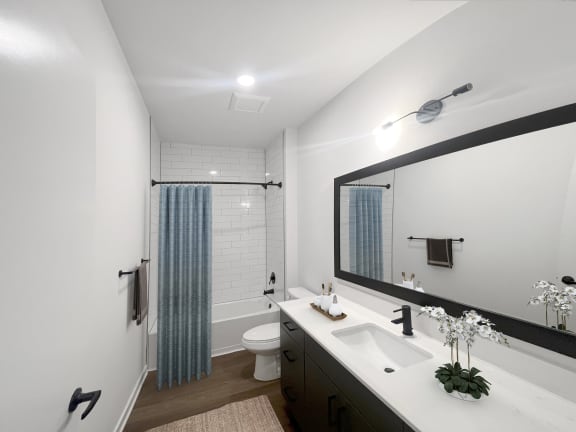 a bathroom with white walls and a blue shower curtain