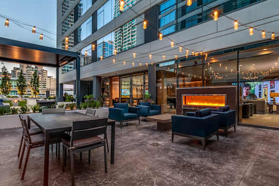 A patio with a table, chairs, and a fireplace.