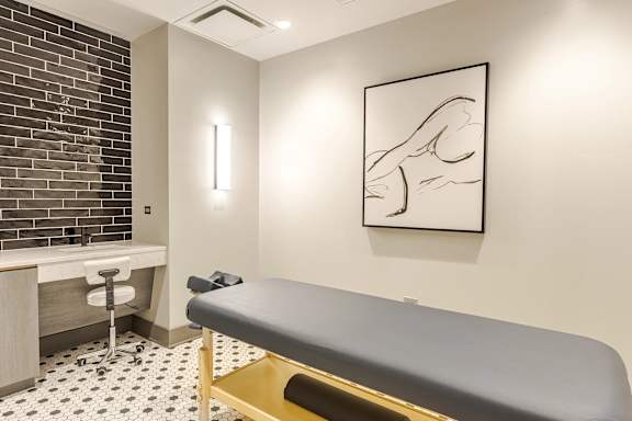 A room with a massage table and a chair.