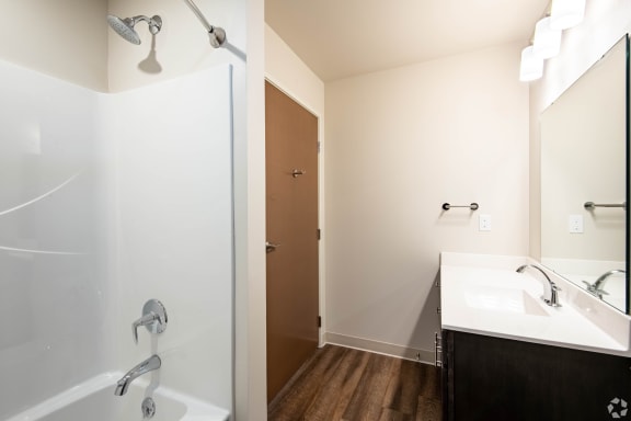 a bathroom with a shower and a sink and a mirror