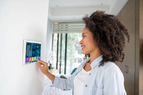 A woman with curly hair is interacting with a tablet.