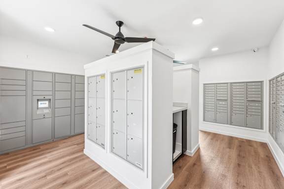 A room with a ceiling fan and a cabinet with drawers.