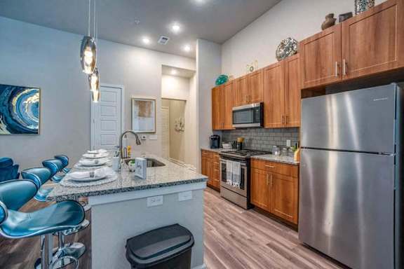 A modern kitchen with wooden cabinets and stainless steel appliances.