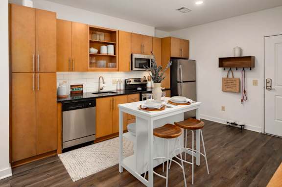 A kitchen with wooden cabinets and a white island.
