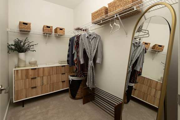 A room with a white wall and a wooden cabinet with drawers.
