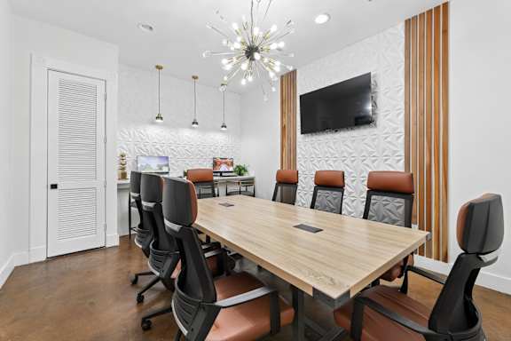 A conference room with a long table and chairs.