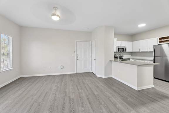 A spacious kitchen with a refrigerator, sink, and cabinets.