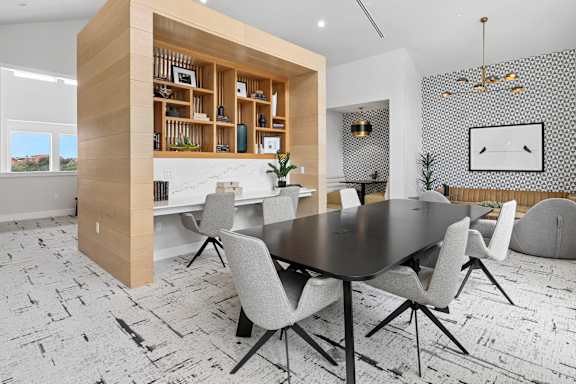 A modern dining room with a round table and chairs.