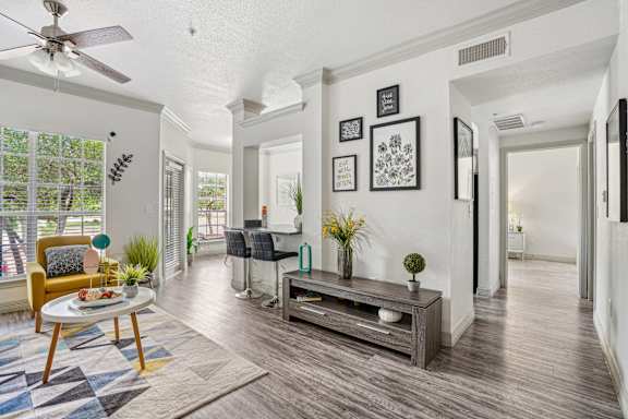A living room with a yellow chair and a wooden coffee table.
