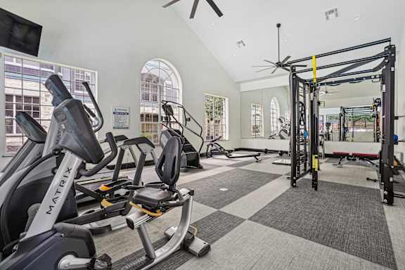 A gym with a variety of equipment including a stationary bike and a pull up bar.