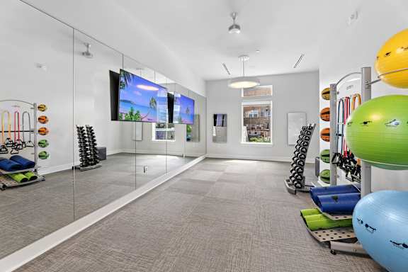 A gym with exercise balls and equipment.
