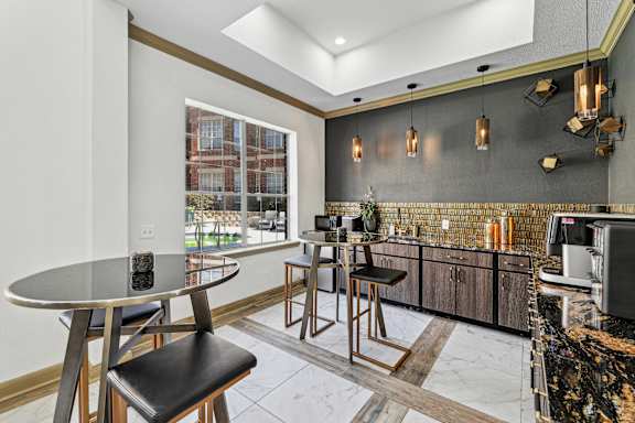 A modern kitchen with a round table and bar stools.