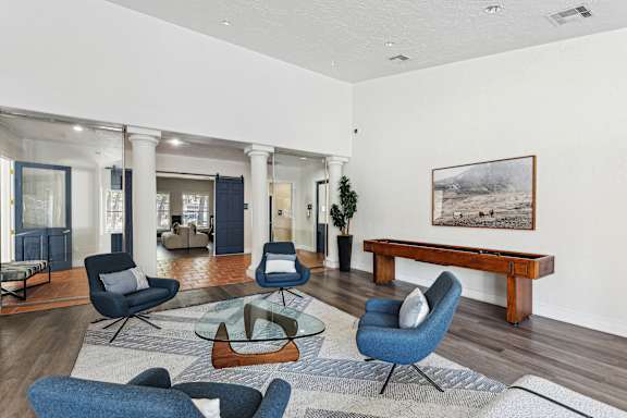 A living room with blue chairs and a wooden bench.