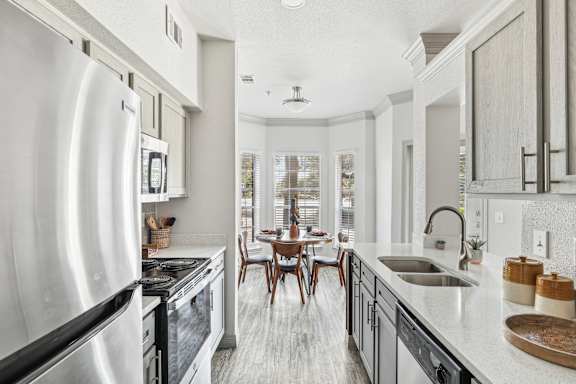 A modern kitchen with a large island and stainless steel appliances.