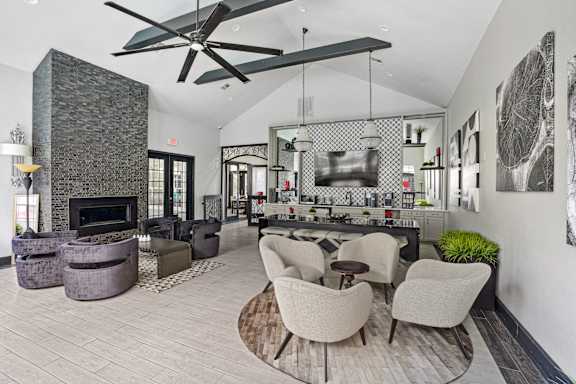 A modern living room with a stone fireplace and a large fan.