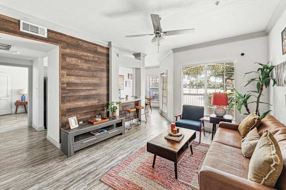 A living room with a wooden floor and a large window.