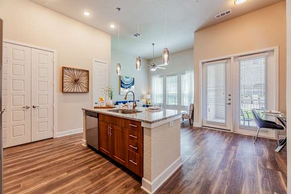 A kitchen with wooden floors and a white island.