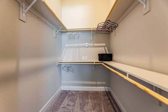 A small, empty room with a desk and a shelf.