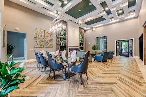 A dining room with a wooden floor and a glass table.