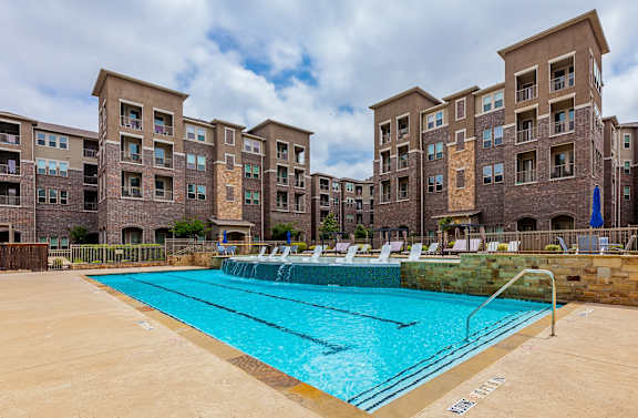 A swimming pool in front of apartment buildings.