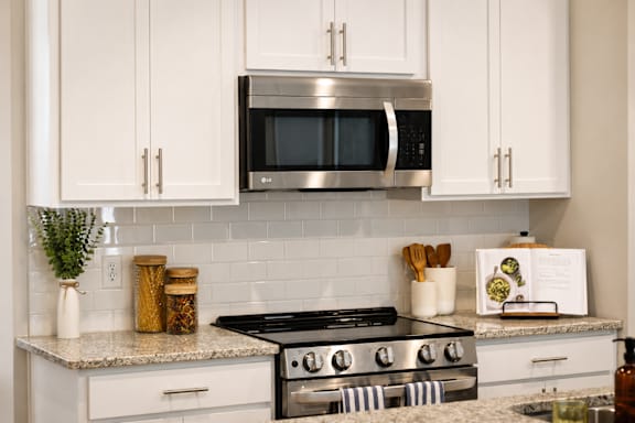 A kitchen with a stove top oven and a microwave above it.