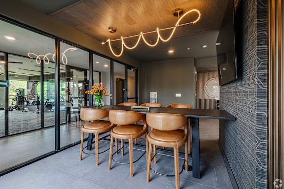 A modern dining area with a wooden table and chairs.