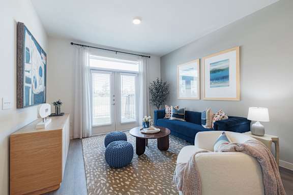 A living room with a blue couch and a white chair.