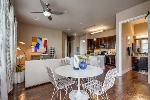 A modern dining room with a white table and chairs.