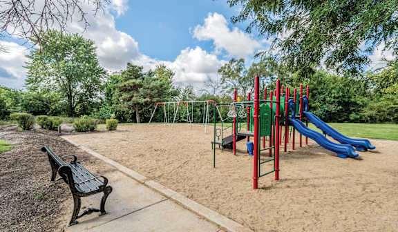 A playground with a blue slide and a green climbing frame.