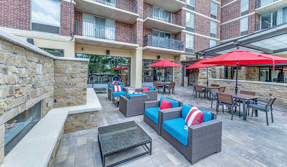 A patio with a stone fireplace and furniture.
